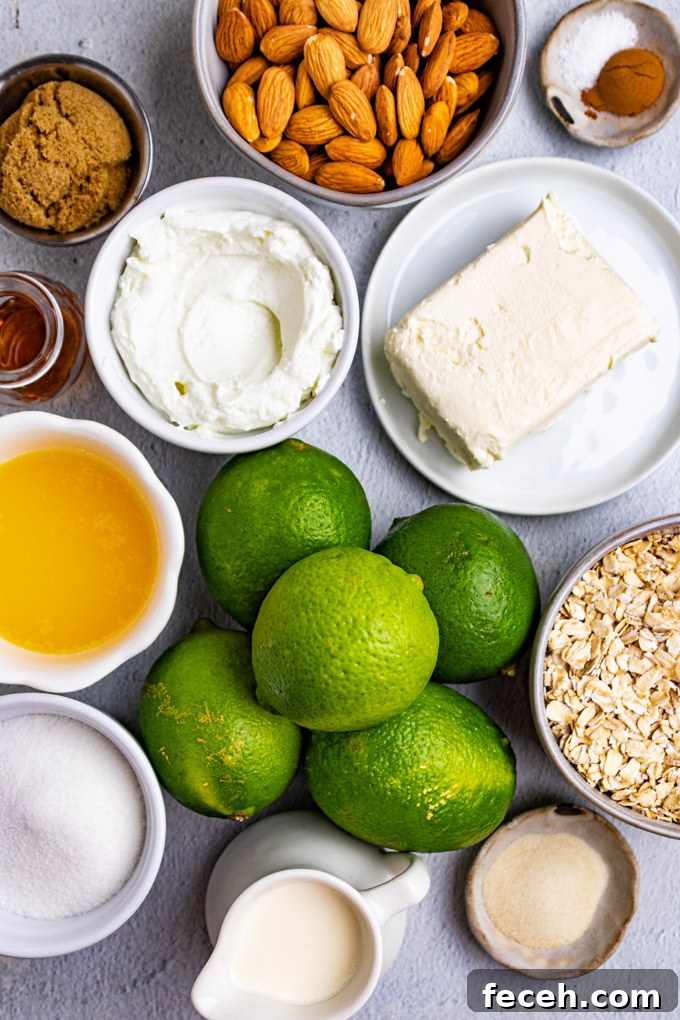 Overhead ingredient shot for key lime pie - limes, cream cheese, almonds, oats, butter, sugar, cream, Greek yogurt.
