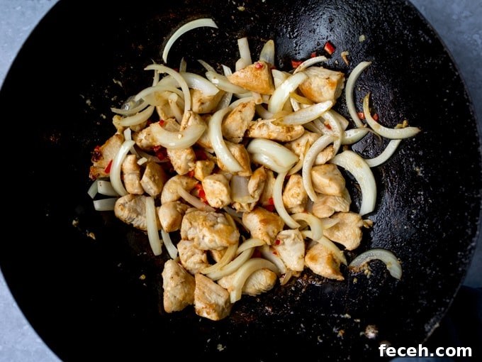 Chicken and onions frying in a wok