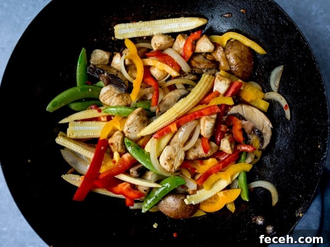 Chicken and vegetables frying in a wok