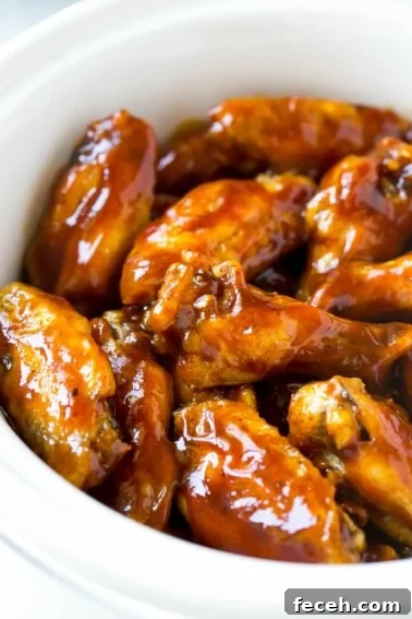 A slow cooker full of barbecue chicken wings.