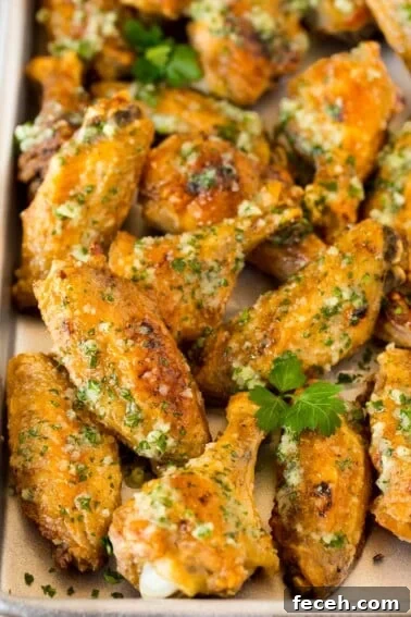 A pan of garlic parmesan wings garnished with parsley.