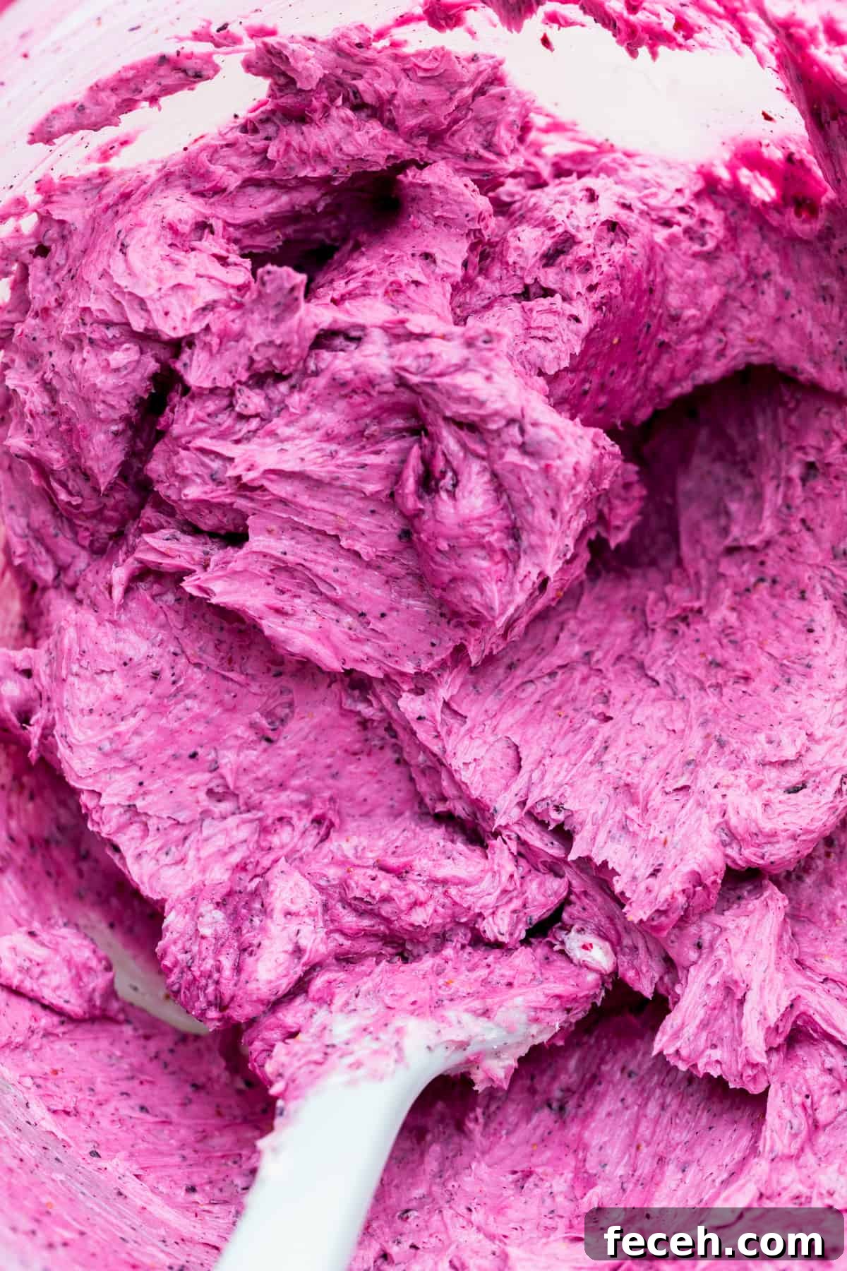 Blueberry frosting in a glass bowl.