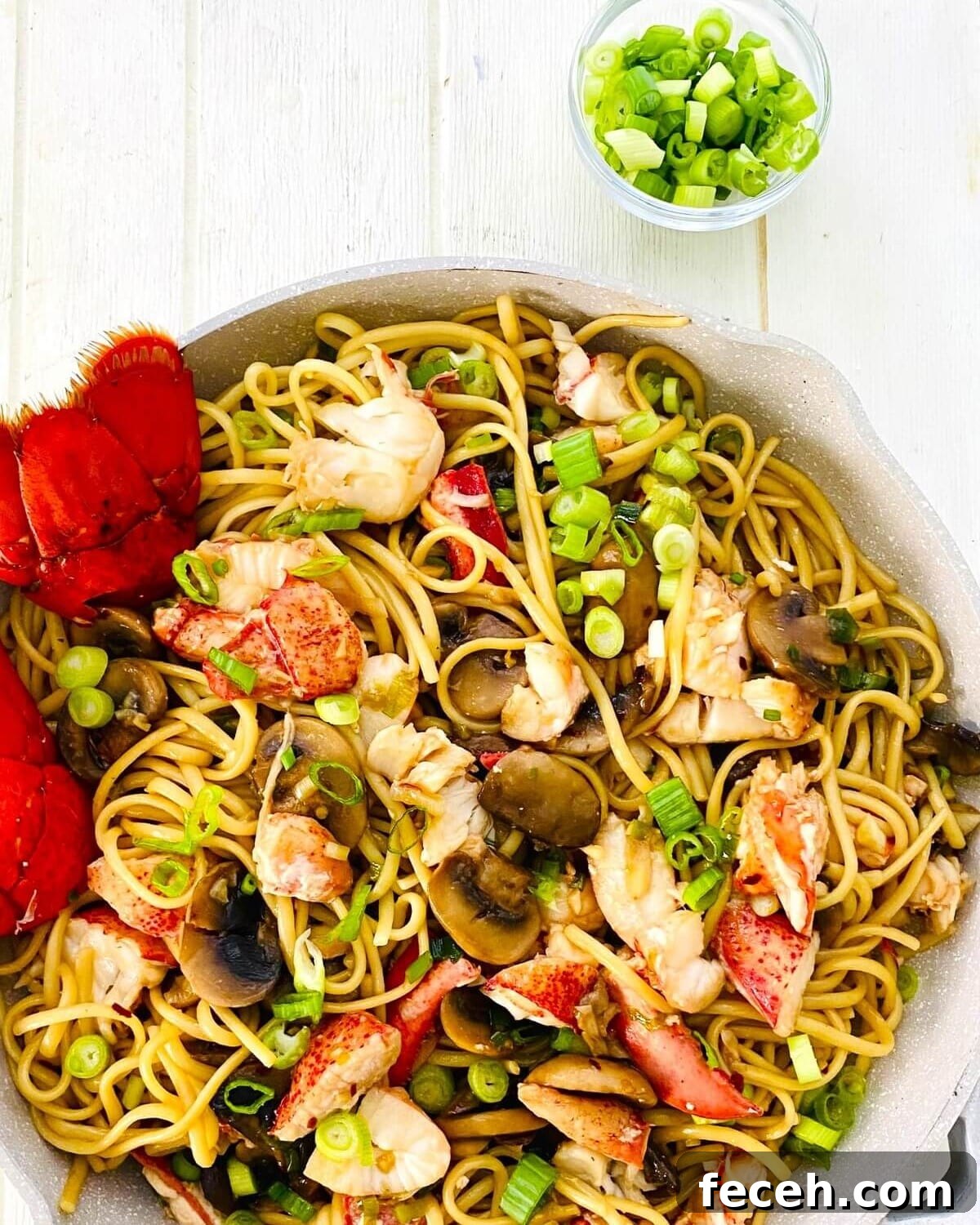 green onions and a pan of lobster noodles.