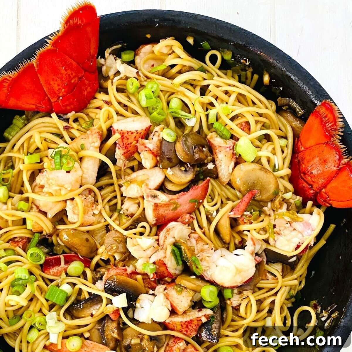 lobster noodles with mushrooms in a sauté pan.