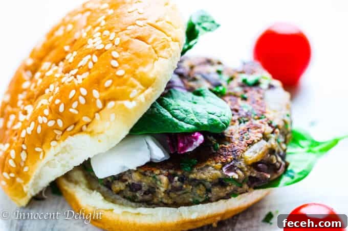 Mushroom burger with black beans on a bun with tomatoes on a side