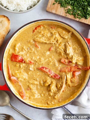 Leftover chicken curry in a pan with rice and naan bread.