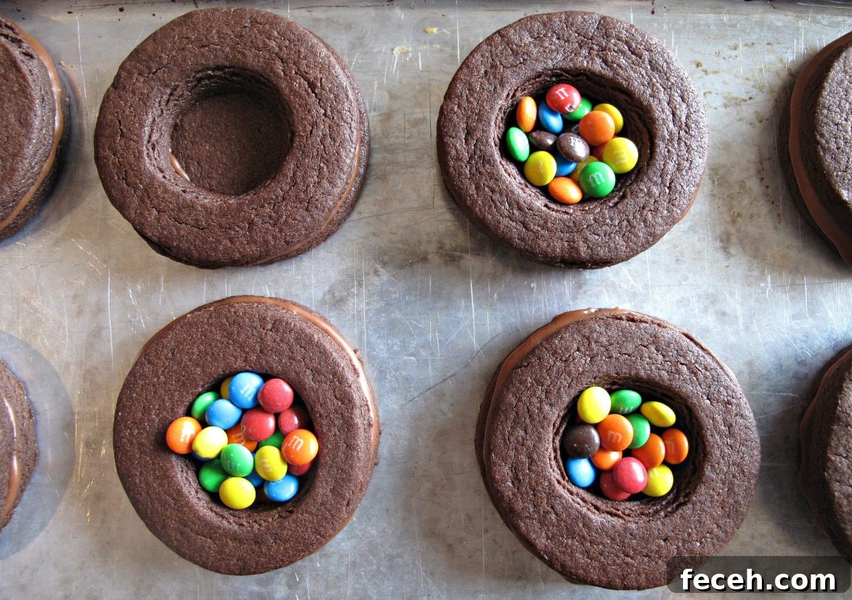 Birthday Cake Cookie Recipe: Soft, Sprinkle-Stuffed Treats 10 Stacked chocolate sugar cookie circles with middle cookie center hole filled with mini m&m's.