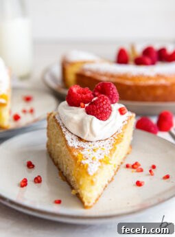slice of french yogurt cake topped with whipped cream and raspberries.