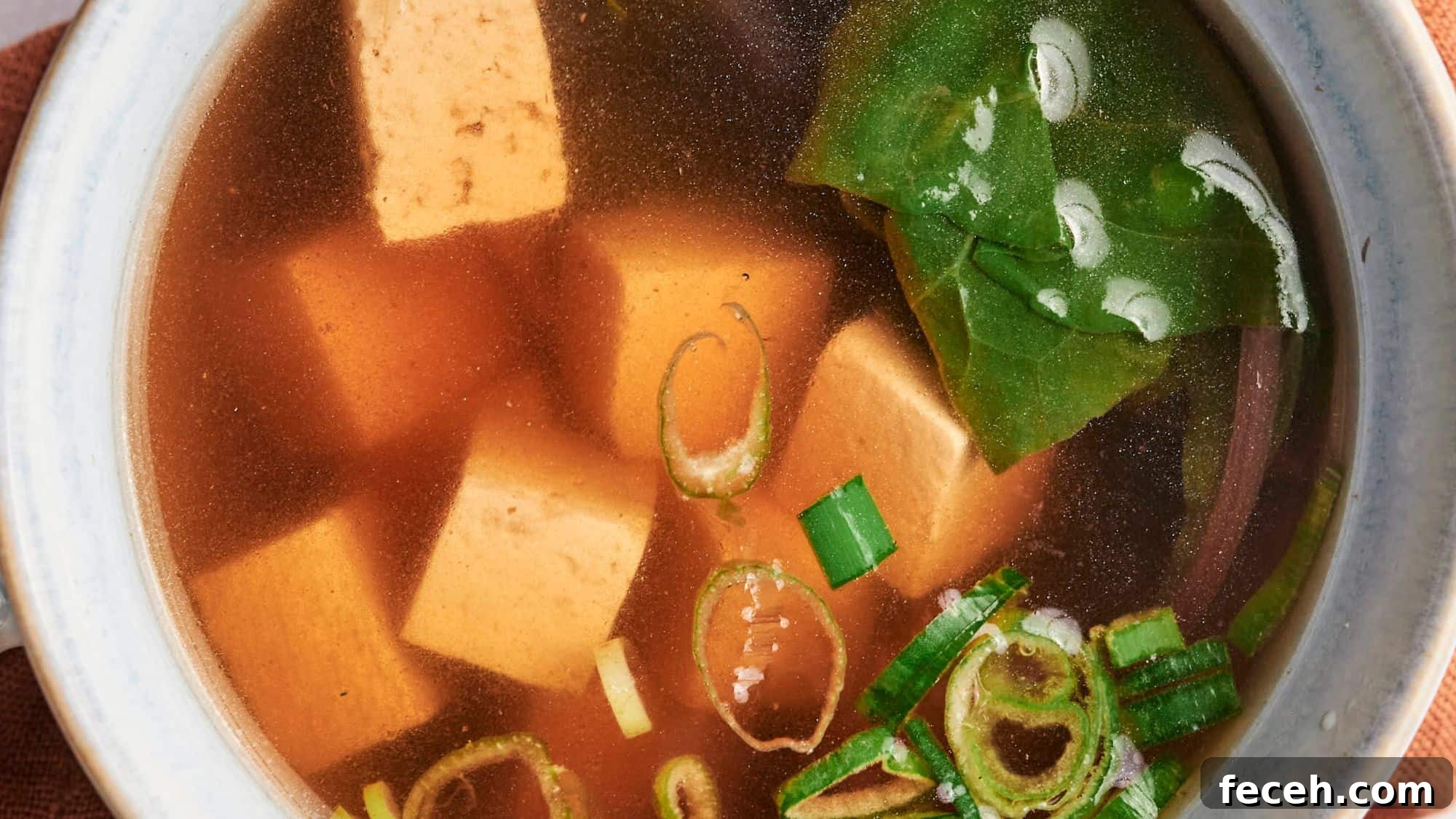 31 Asian Weeknight Dinners to Make Mealtime Exciting 13 A bowl of miso soup with tofu cubes, seaweed, and green onions.