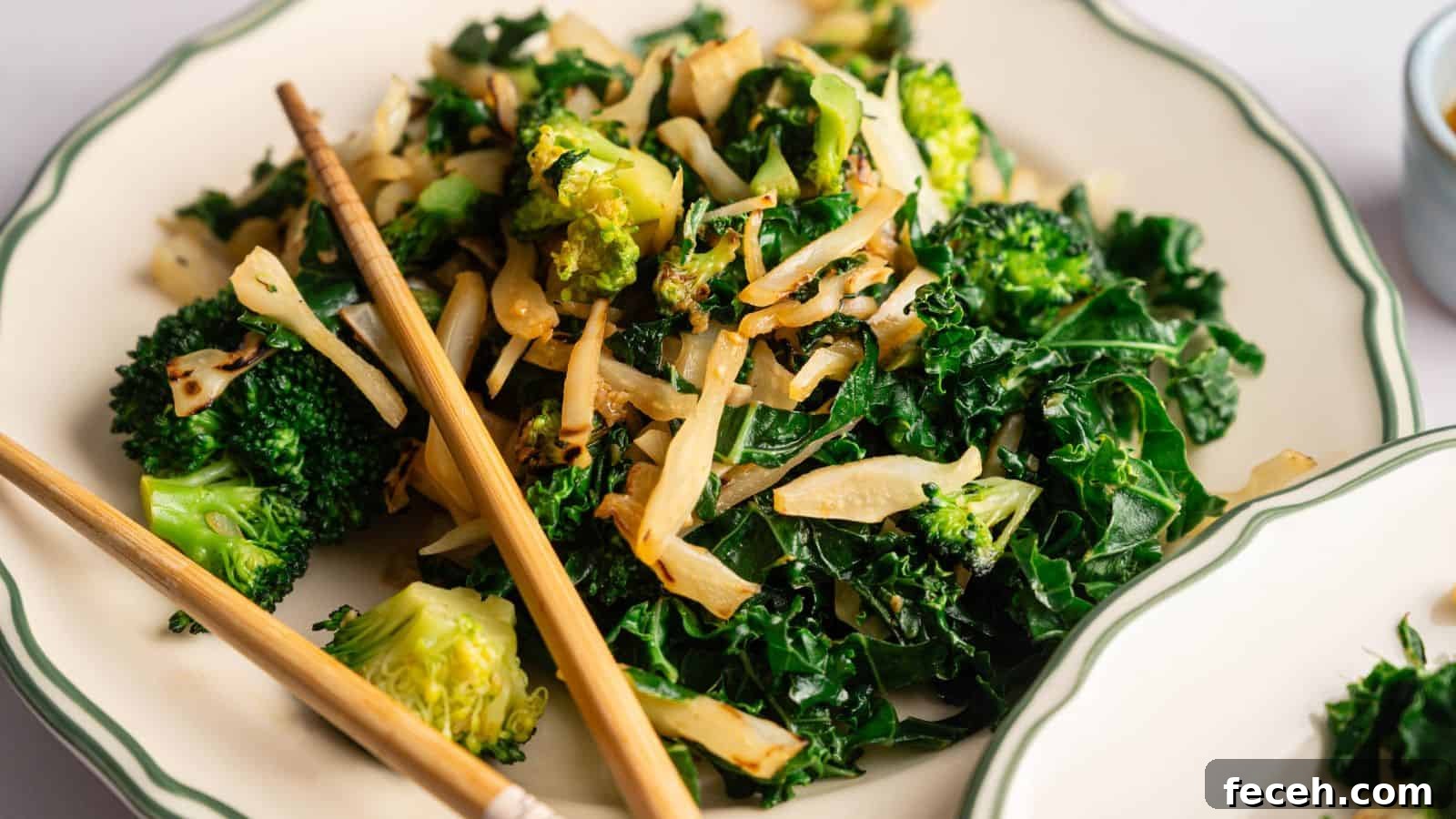 31 Asian Weeknight Dinners to Make Mealtime Exciting 15 A plate of stir-fried kale, broccoli, and sliced onions, served with a pair of chopsticks on the side.