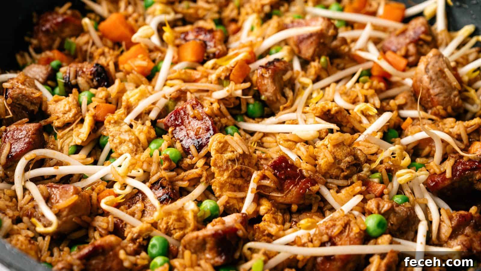 31 Asian Weeknight Dinners to Make Mealtime Exciting 3 Close-up of fried rice with chunks of meat, peas, diced carrots, and bean sprouts mixed together.
