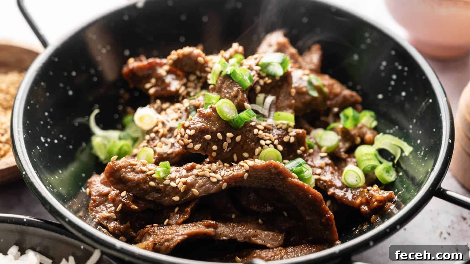 31 Asian Weeknight Dinners to Make Mealtime Exciting 4 A bowl of cooked beef slices topped with sesame seeds and chopped green onions.