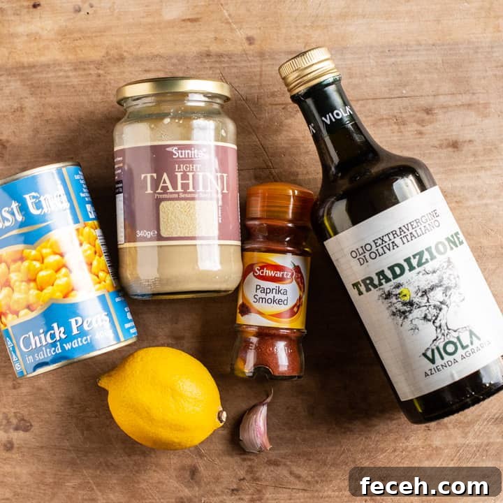 wooden background with various canned ingredients used to make hummus