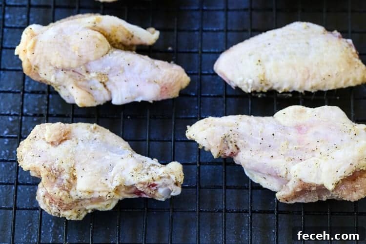 These Crispy Buffalo Chicken Wings are SO addicting and fall off the bone tender! A few tips make them as crispy as if you fried them! chicken wings on a baking rack