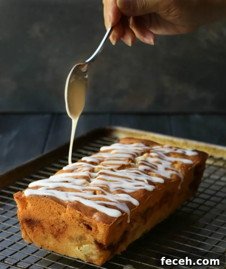 White glaze drizzled from a spoon over the top of Apple Fritter Bread