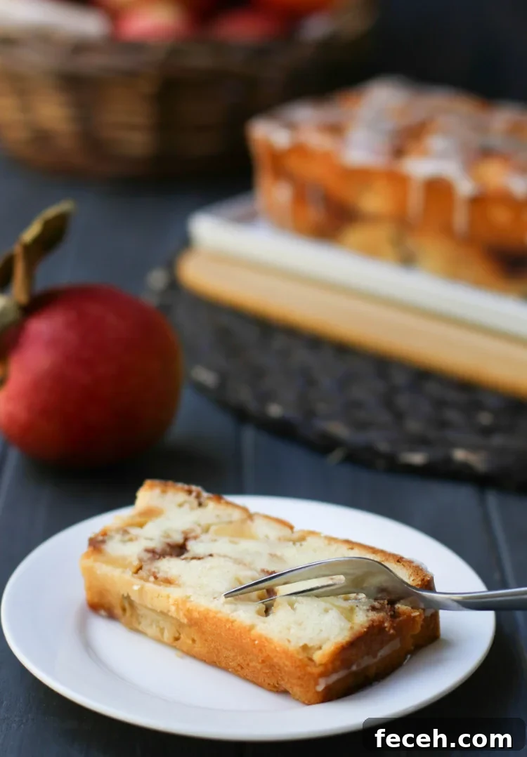 Once slice of Apple Fritter Bread on a white plate with a fork cutting into it.