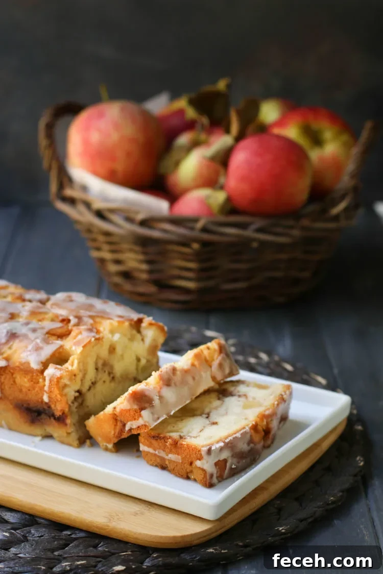 Sliced Apple Fritter Bread on a white plate in front of a basket of apples.