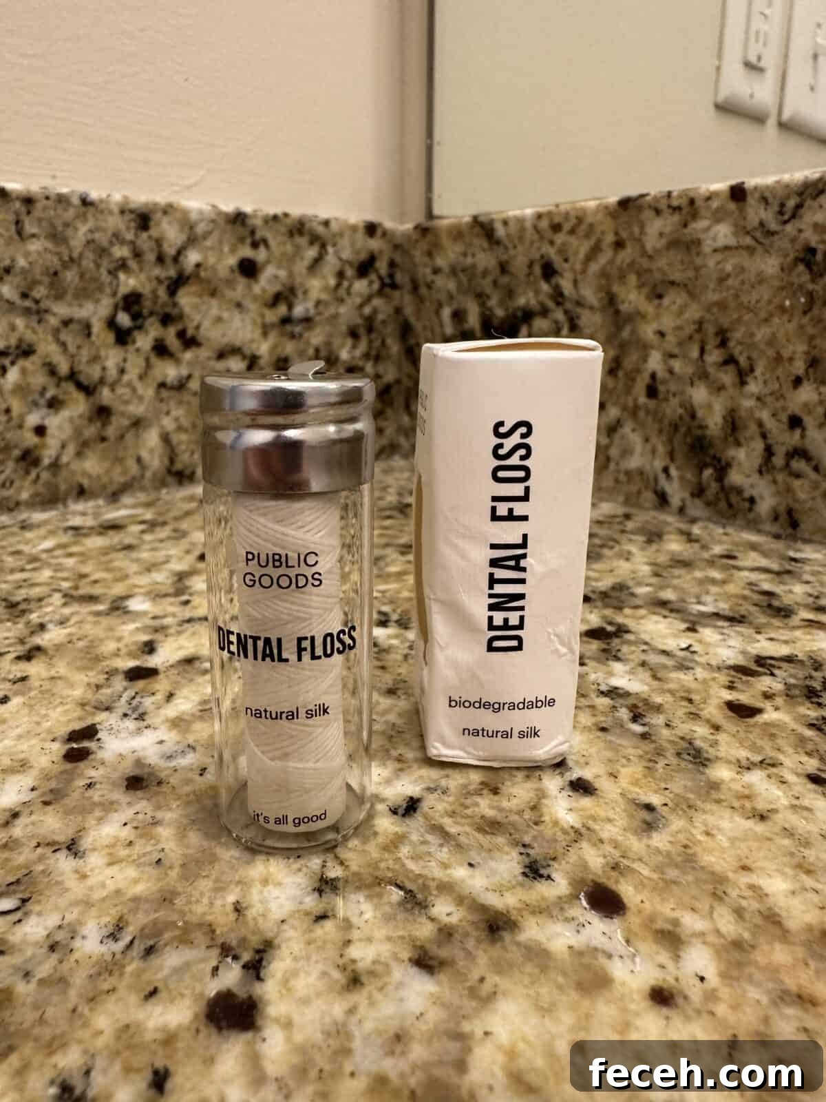 Are Public Goods Products Worth It? A Deep Dive Into Their Ingredients 4 Glass container of Public Goods natural silk dental floss next to its white biodegradable paper box on a granite countertop.