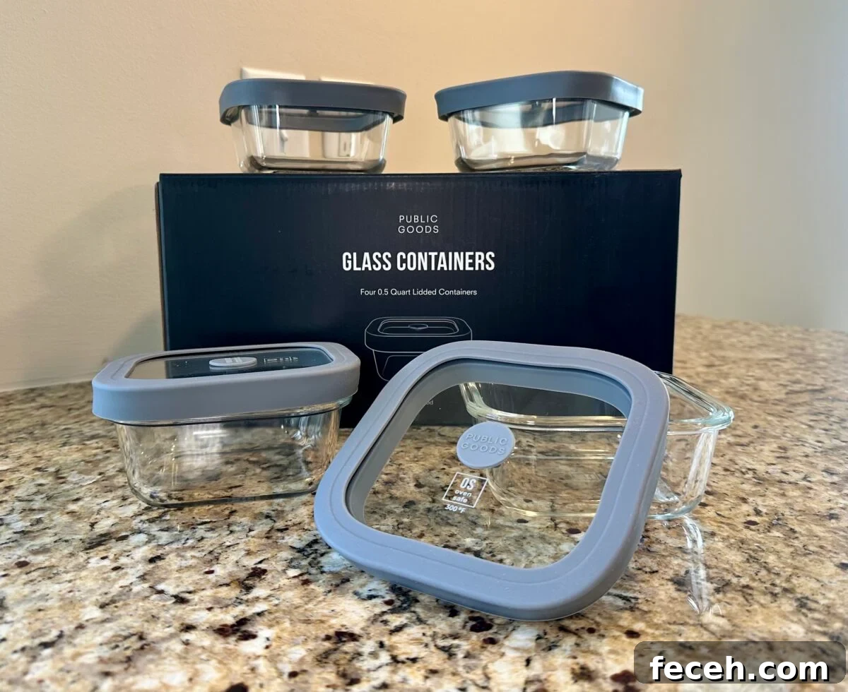 Are Public Goods Products Worth It? A Deep Dive Into Their Ingredients 5 Public Goods glass food storage containers with gray lids displayed on a granite countertop in front of the product box.