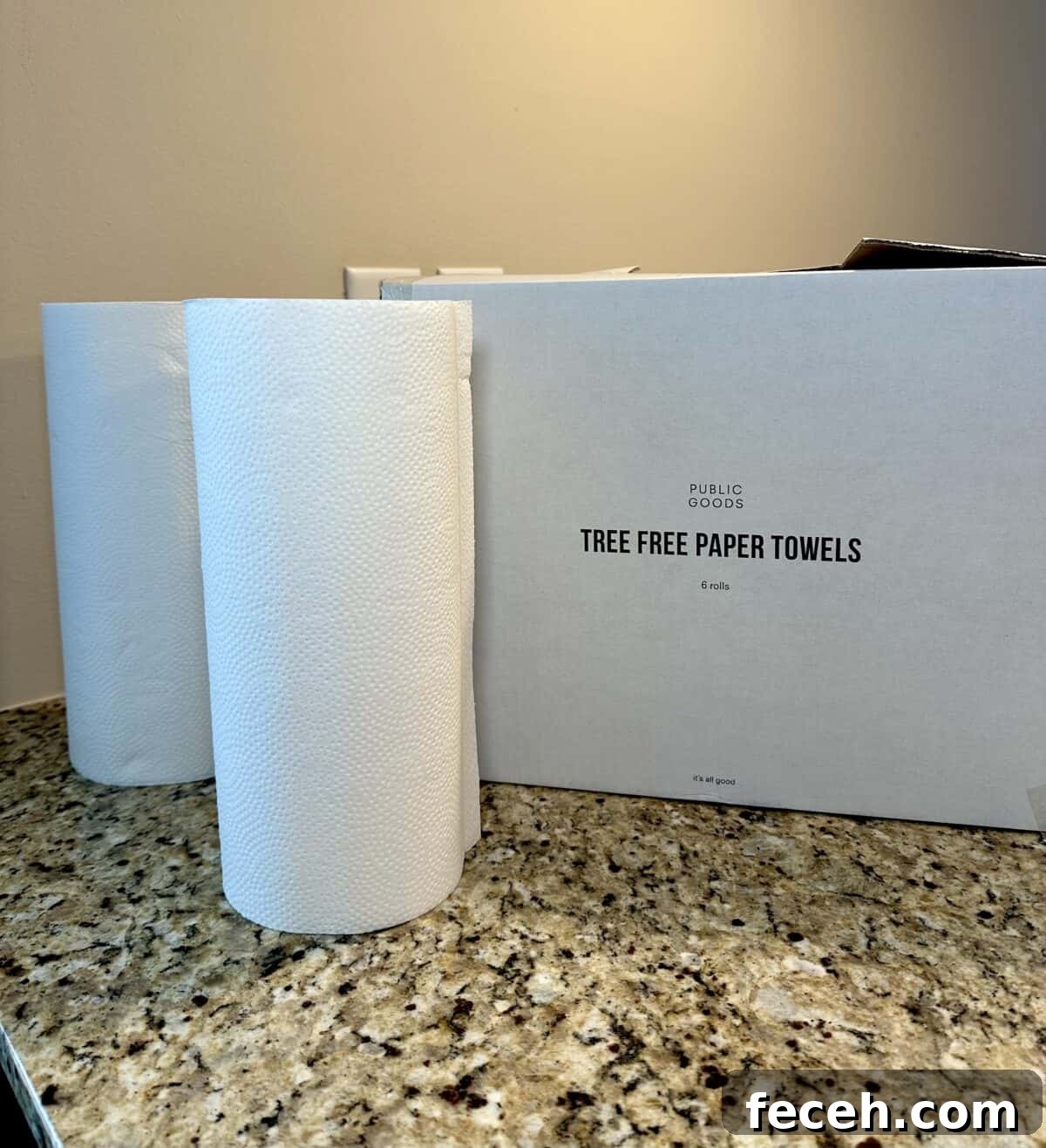 Are Public Goods Products Worth It? A Deep Dive Into Their Ingredients 7 The photo shows two rolls of white paper towels standing next to their large white "TREE FREE PAPER TOWELS" packaging box on a granite countertop.