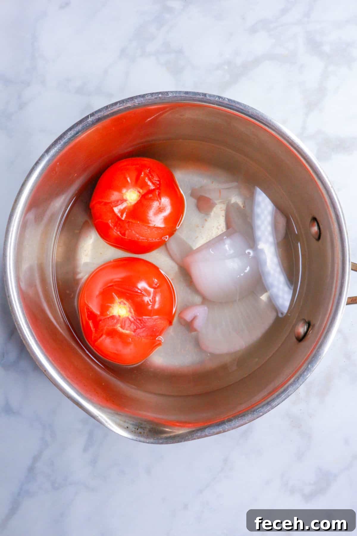 Pot with boiled tomatoes and onion