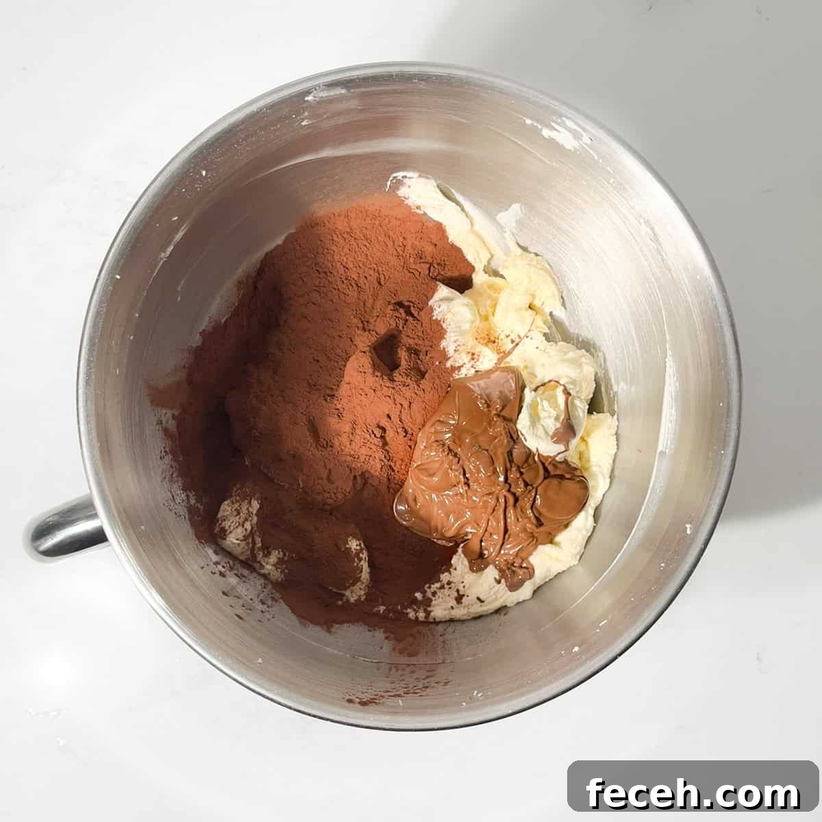 Adding melted chocolate and cocoa powder to the chocolate orange buttercream.