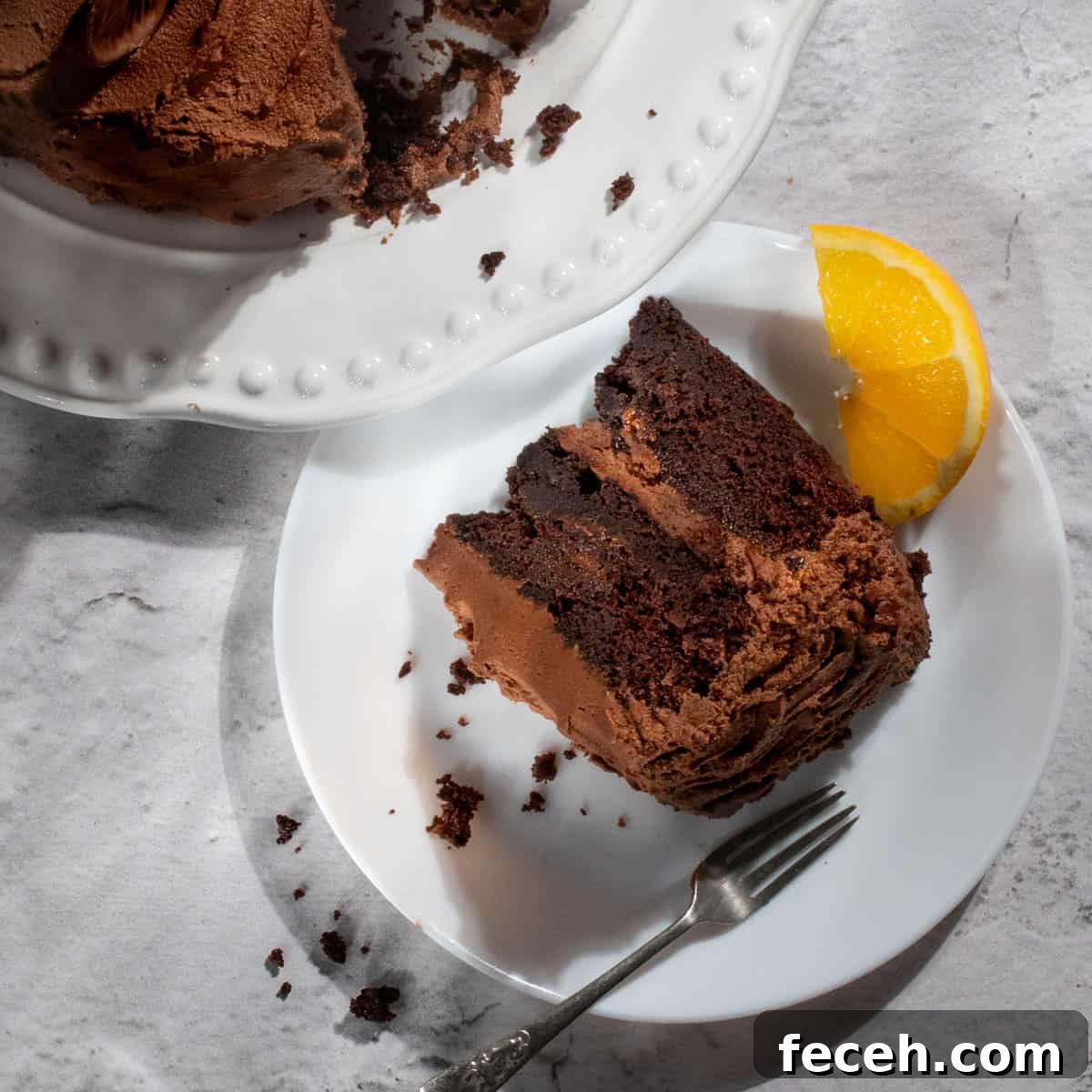 A slice of chocolate orange cake on a white plate.