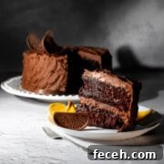 Chocolate orange cake on a white plate with a slice in the foreground.