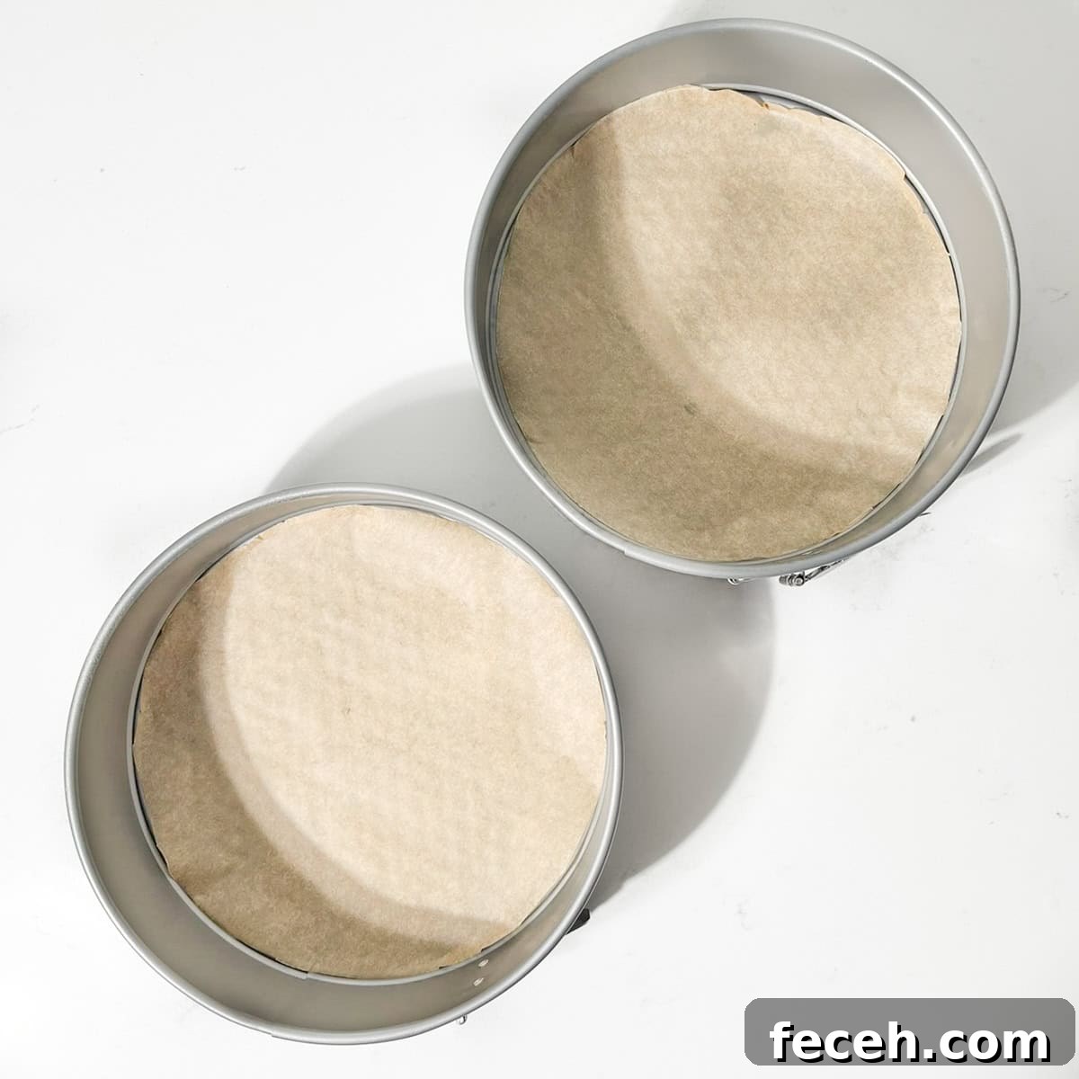 Two prepared round cake tins.