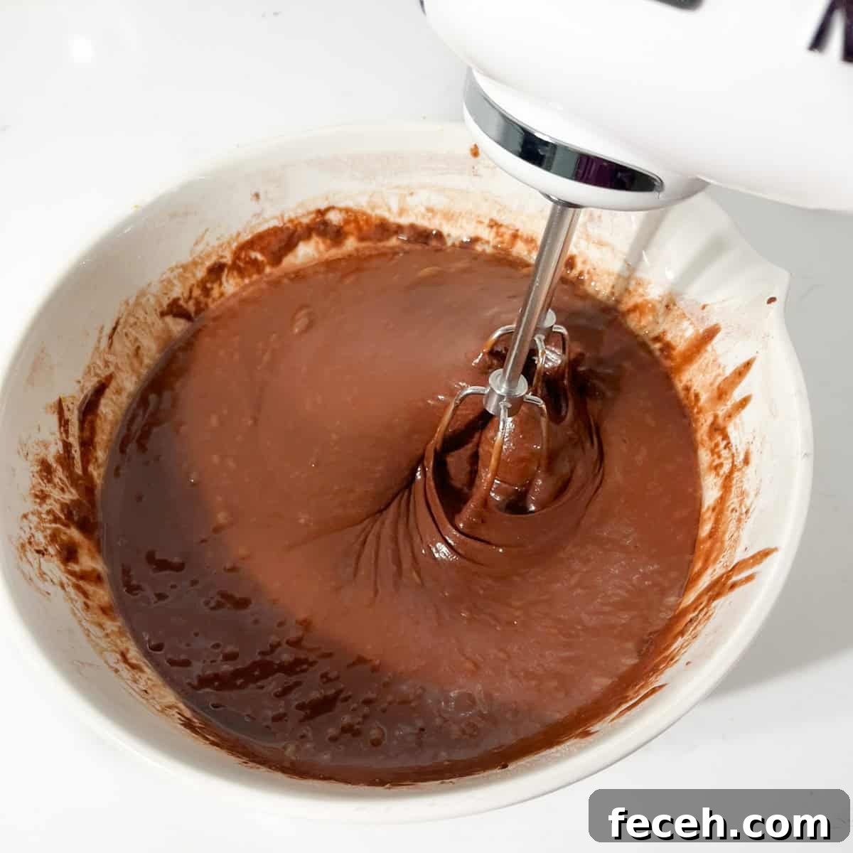 Whisking the batter for the chocolate orange cake with an electric hand mixer.