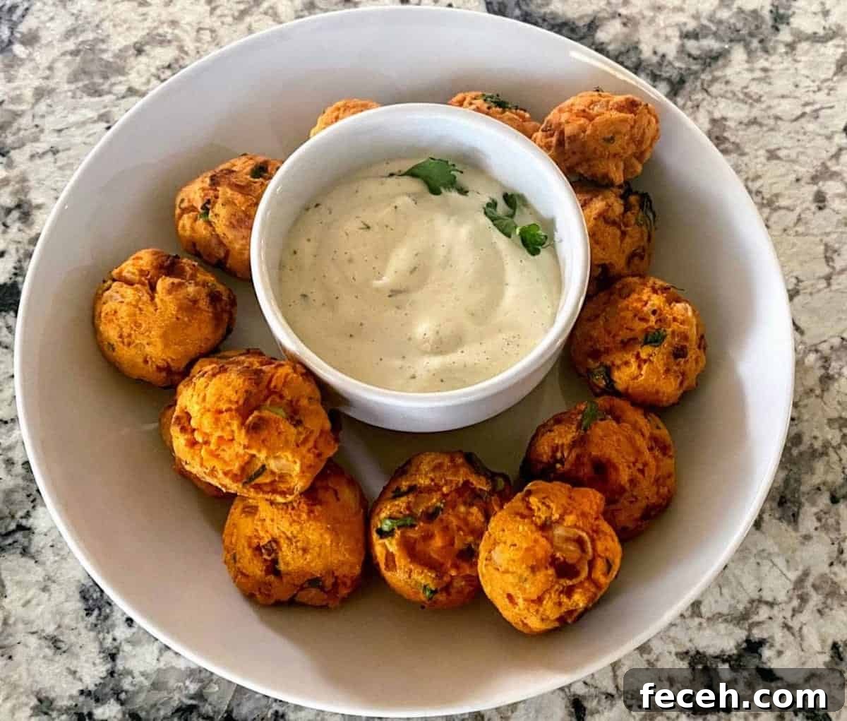 The recipe is in a bowl with ranch dressing in the center on the counter. 