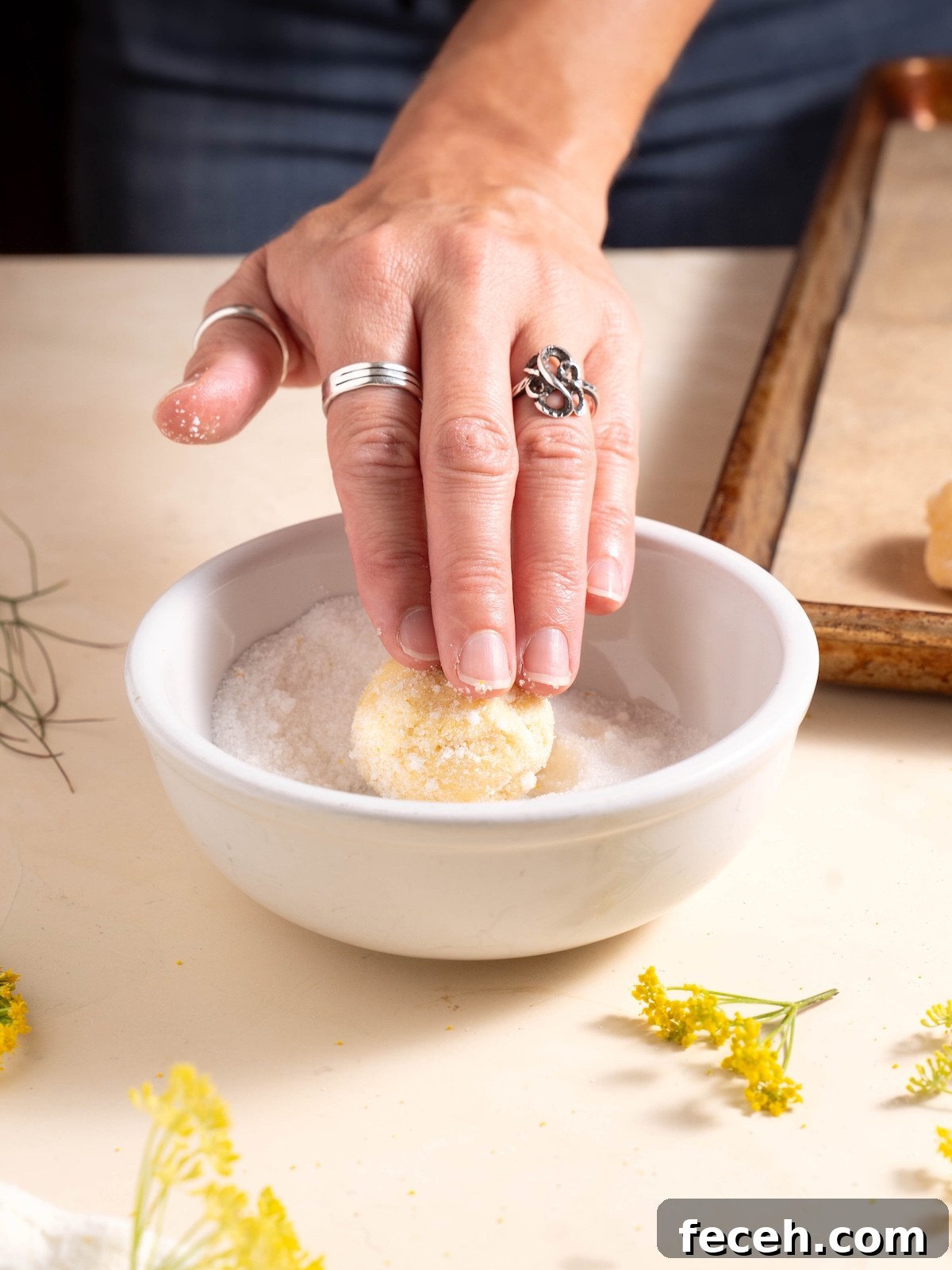 Rolling cookie dough in fennel pollen sugar