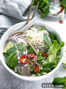 15 Global Soups and Hearty Stews to Warm Any Night 12 A bowl of pho with vegetables, beef, and noodles.