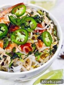 15 Global Soups and Hearty Stews to Warm Any Night 13 A bowl with chicken and shrimp pho soup with vegetables and noodles.