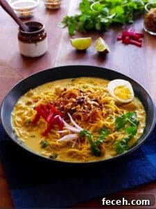 15 Global Soups and Hearty Stews to Warm Any Night 17 A bowl of Burmese noodle dish with boiled egg half, peppers, onions, and parsley.