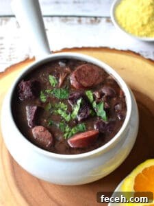 15 Global Soups and Hearty Stews to Warm Any Night 21 Black bean and sausage stew in a white serving bowl.