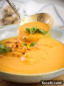 15 Global Soups and Hearty Stews to Warm Any Night 10 Grabbing peanut butter soup in a bowl with a spoon.