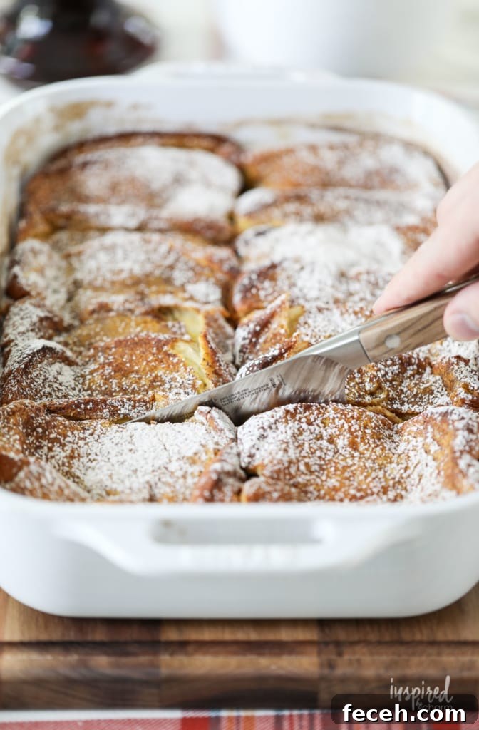 a hand with a knife cutting into pumpkin french toast casserole.
