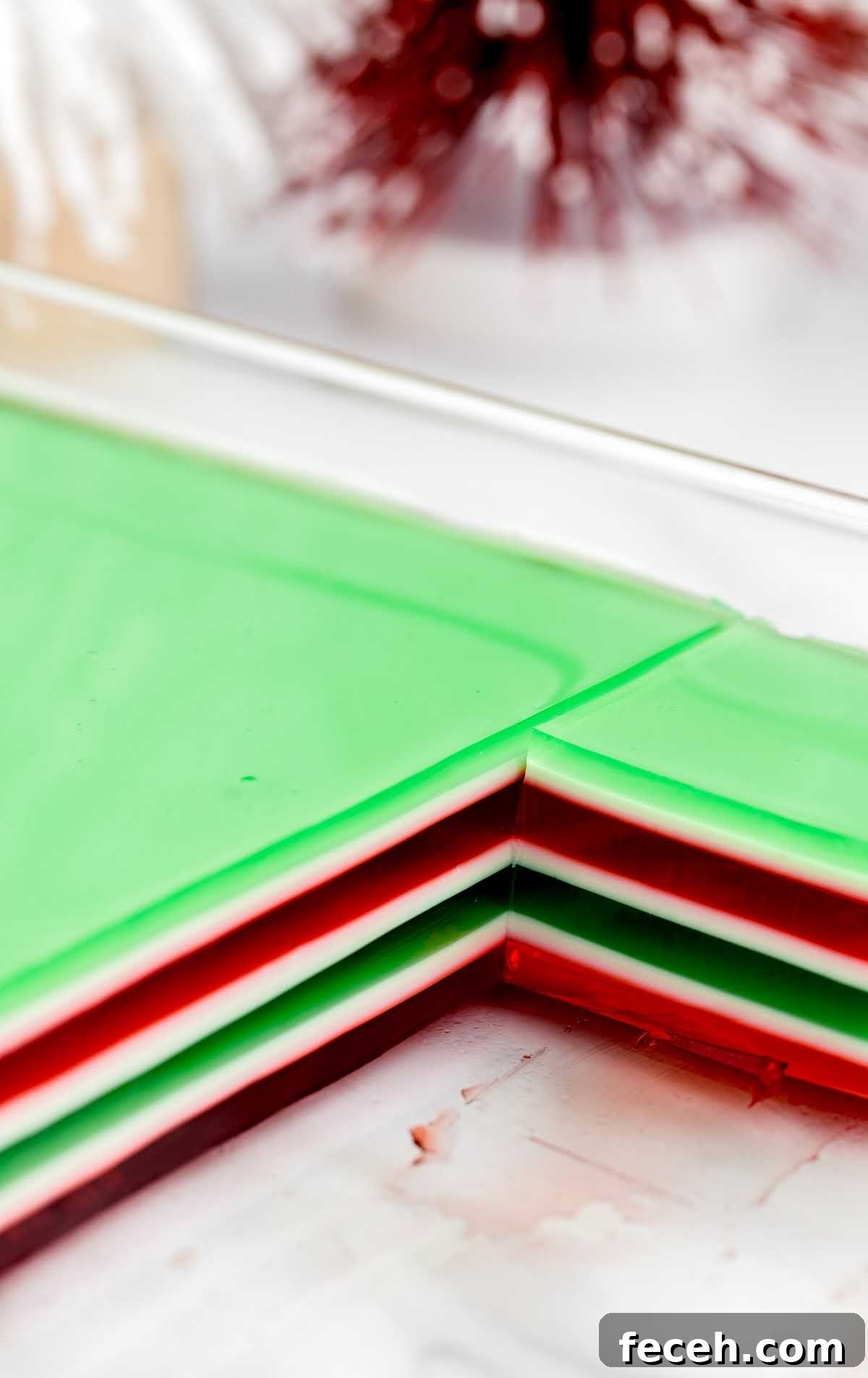 a close up shot of Holly Jolly Jello Shots in a baking dish with pieces taken out