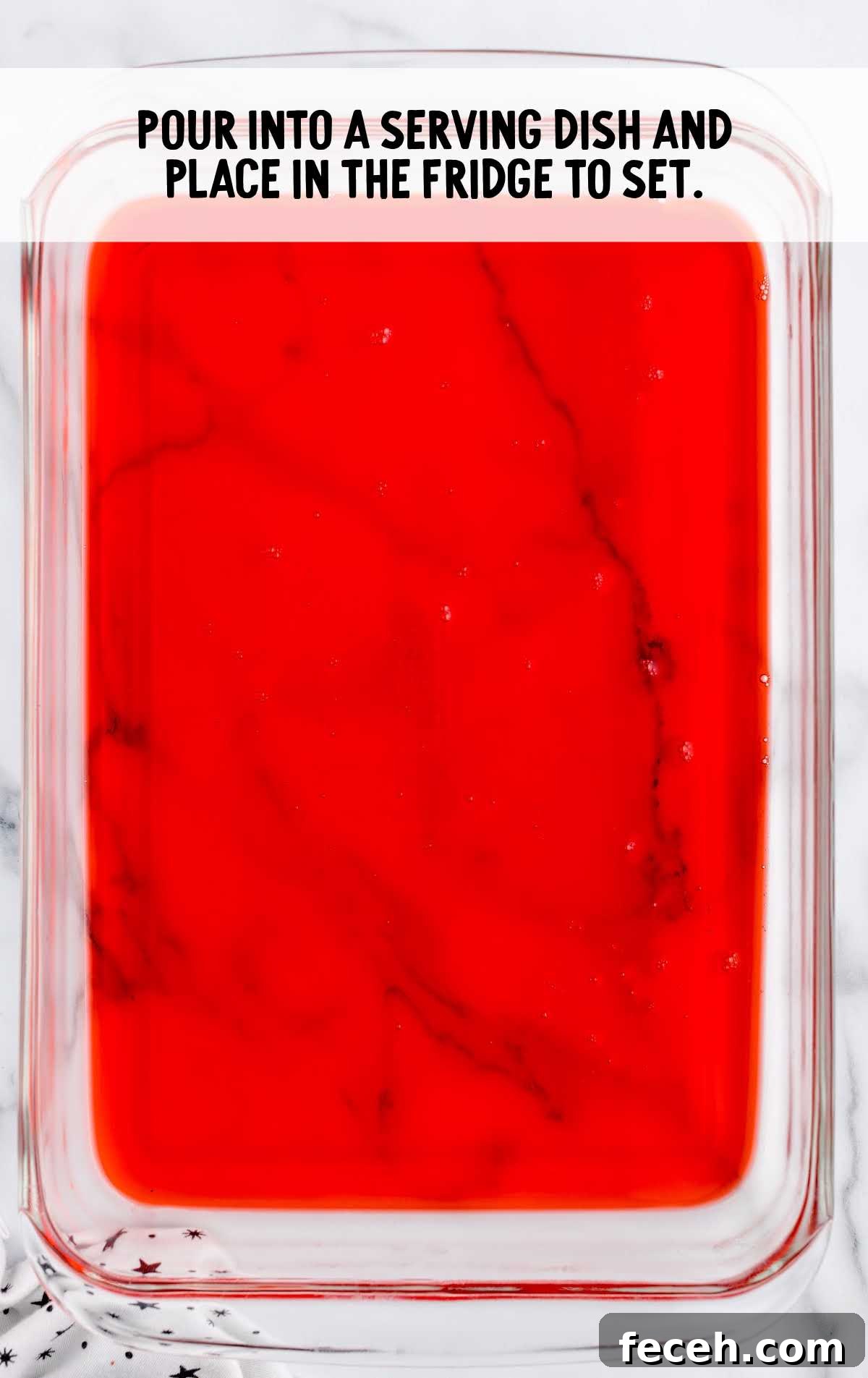 raspberry jello mixture poured in a baking dish