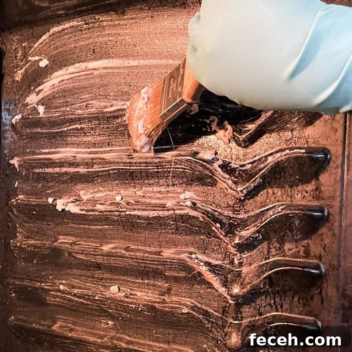 brushing cleaning paste onto oven walls