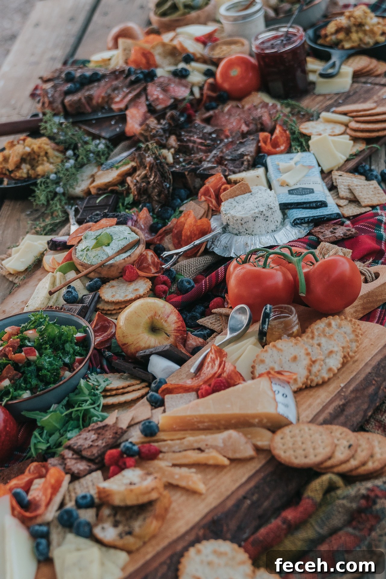 Abundant table filled with crackers, meats, cheeses, and more.