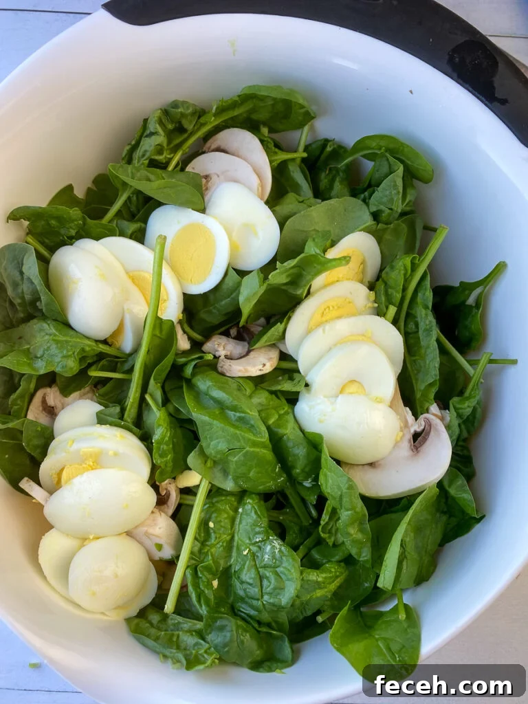 Spinach Salad with Bacon, Mushrooms, and Warm Balsamic Dressing 8 Sliced hard boiled eggs fanned out on top of mushroom and spinach salad.