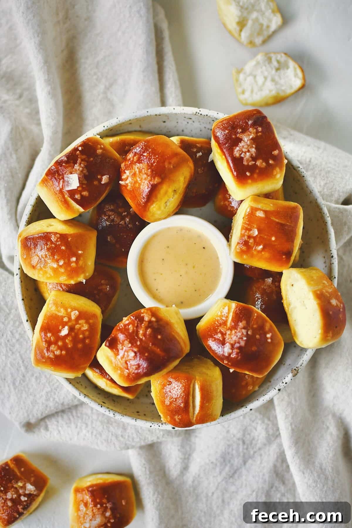 Soft Homemade Pretzel Bites Recipe for Perfect Party Snacks 2 Homemade Pretzel Bites on a platter with cheese sauce in the middle for dipping.