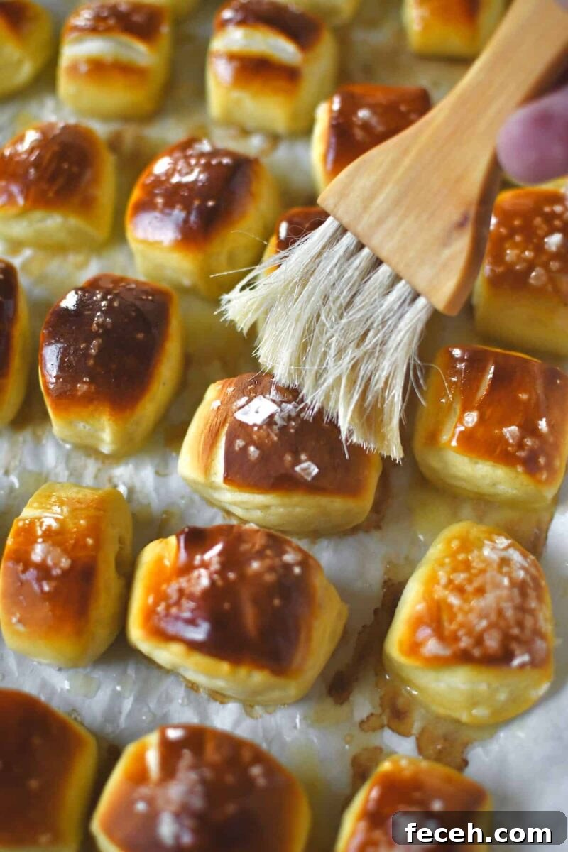 Soft Homemade Pretzel Bites Recipe for Perfect Party Snacks 14 Brushing the baked pretzel bites with melted butter after baking.