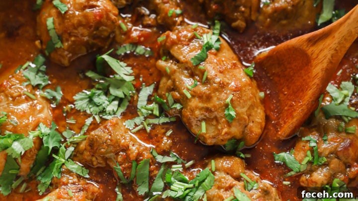 Authentic Chicken Curry in a dutch oven garnished with cilantro