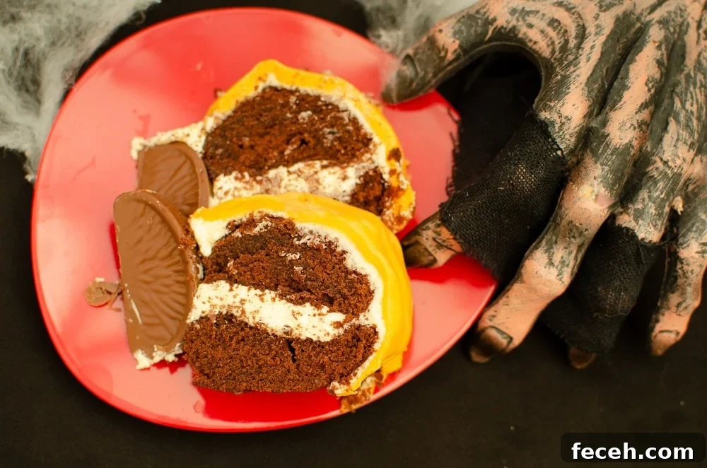 Slices of Pumpkin shaped cake with Chocolate Orange-Halloween party idea served on a red plate being held down by a zombie hand for Halloween