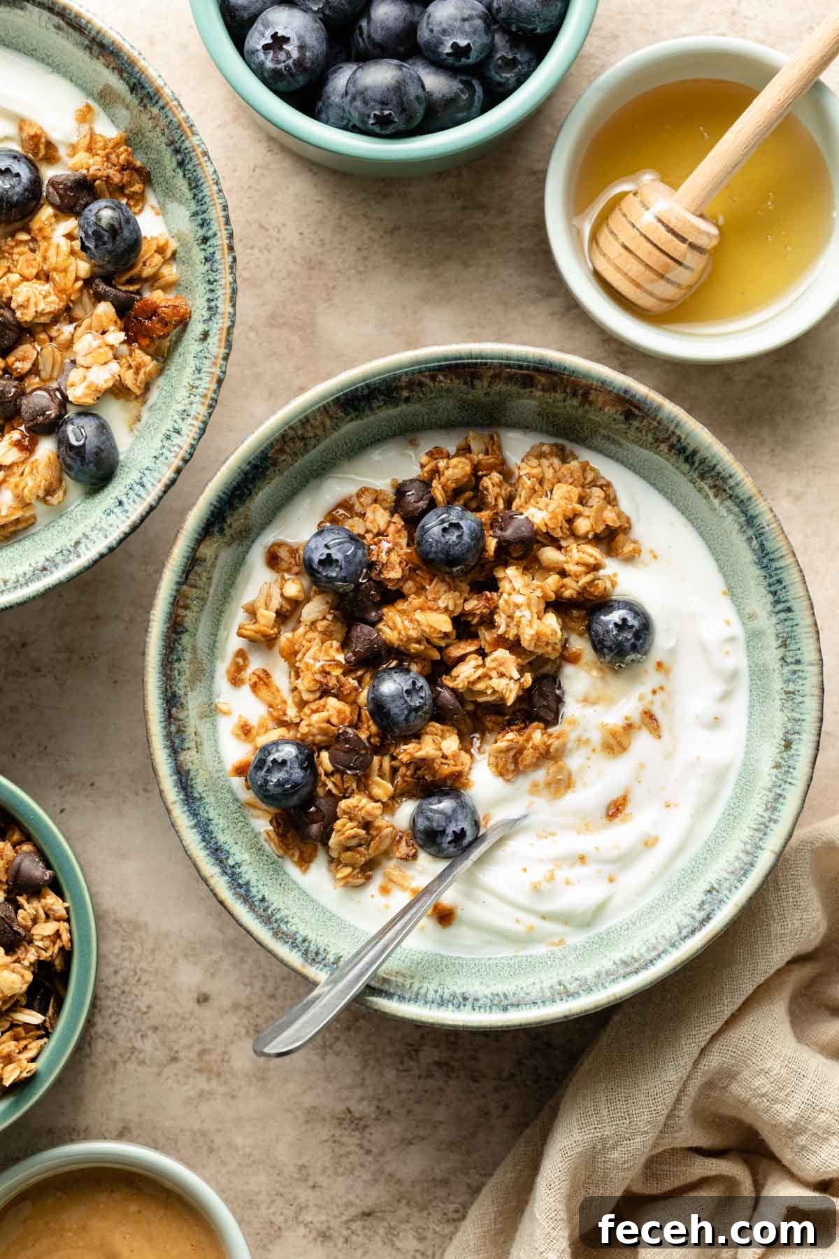 A bowl of yogurt with granola, honey and blueberries on top. 