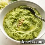 Small white bowl full of zucchini pesto.