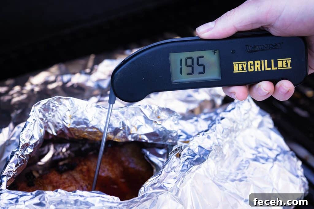 Meat thermometer reading 195 degrees F in a rack of ribs.